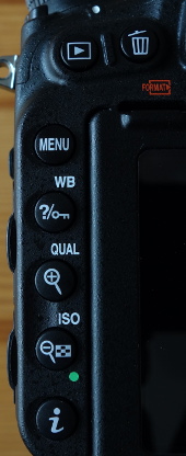 Buttons on the left rear side of the camera. The 2nd from below either zooms out, or changes ISO, depending on whether the camera is in review mode, or not.